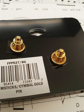 Bild på baksidan av guldfärgade pins i form av en cymbal och två trumpinnar